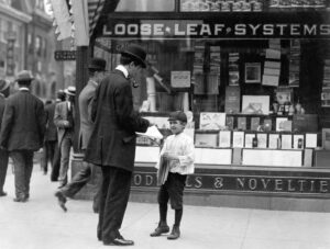 a newsboy selling a newspaper